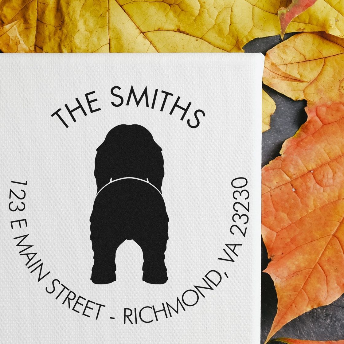 Black custom stamp seal with dog silhouette, THE SMITHS, and curved address on white, set against yellow-orange autumn leaves.