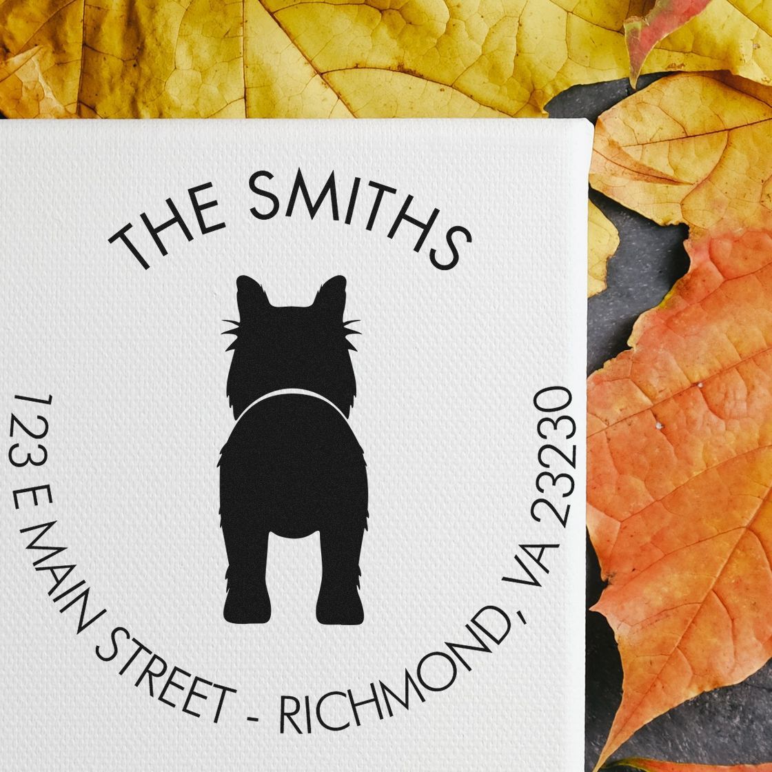 Custom white stamp seal with black cat silhouette, The Smiths, and address, on yellow and orange autumn leaves.