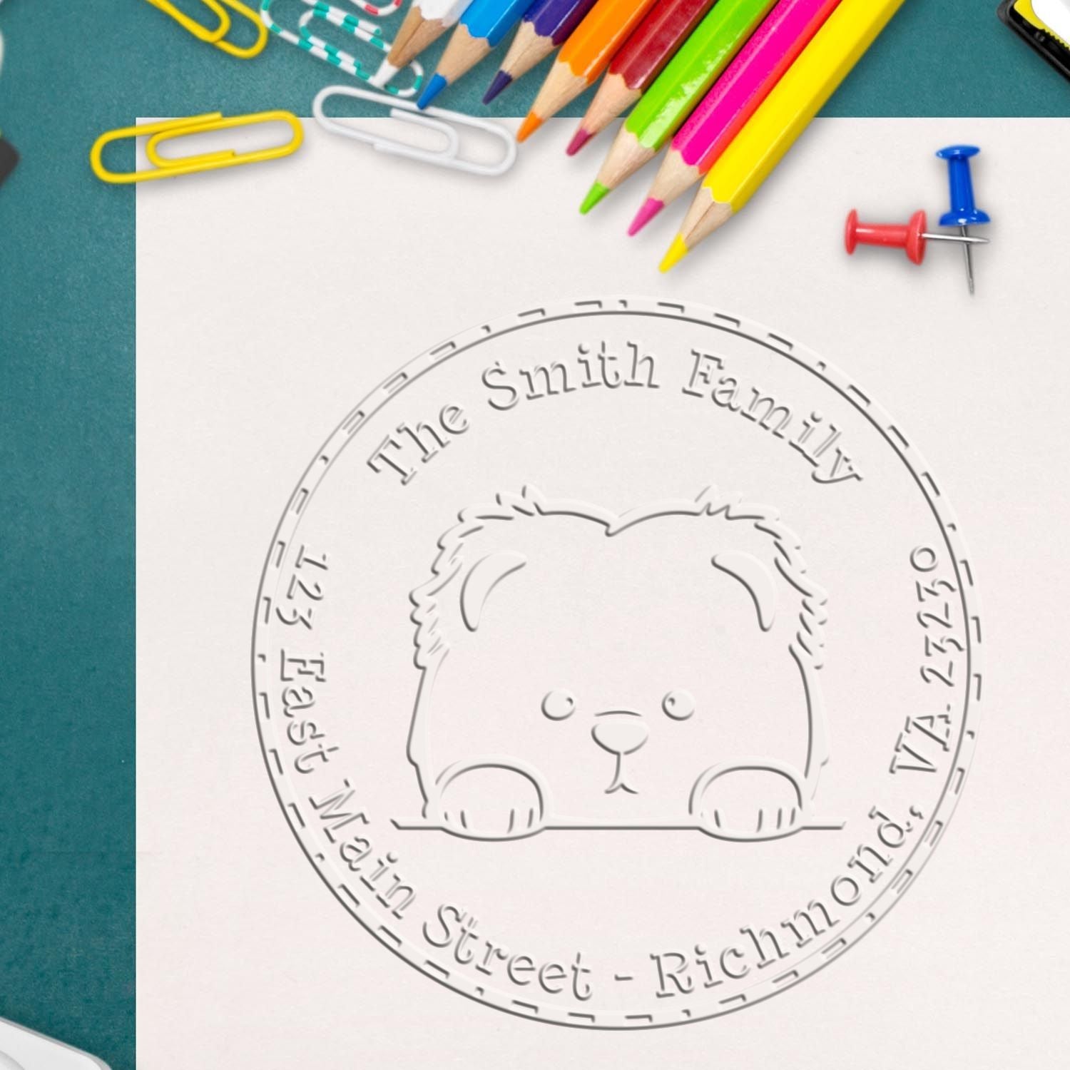 Embossed round stamp and seal with teddy bear logo and The Smith Family text, framed by colorful pencils and paperclips.