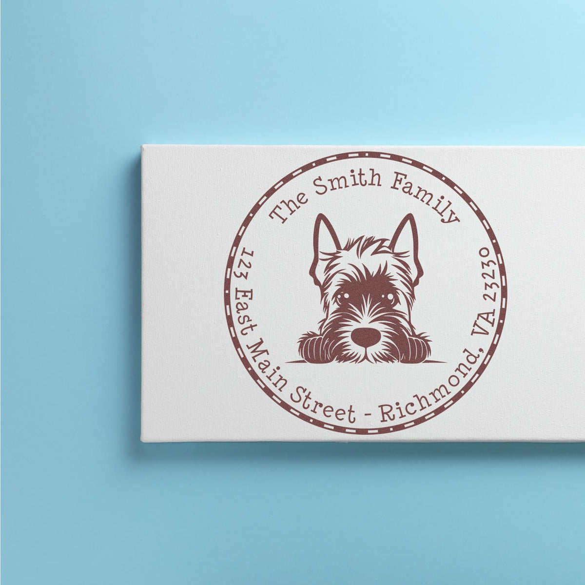 Custom brown dog stamp seal with family name and address on a white canvas against a light blue background