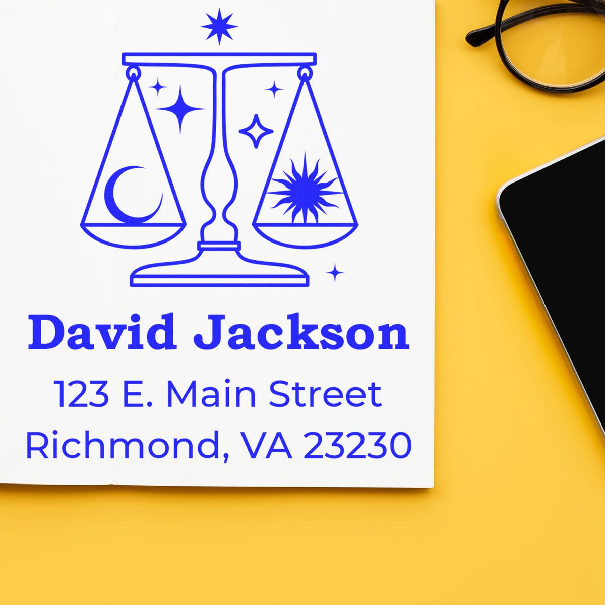 Blue legal stamp and seal with scales, stars and crescent moon, plus David Jackson address on white paper beside glasses and phone.