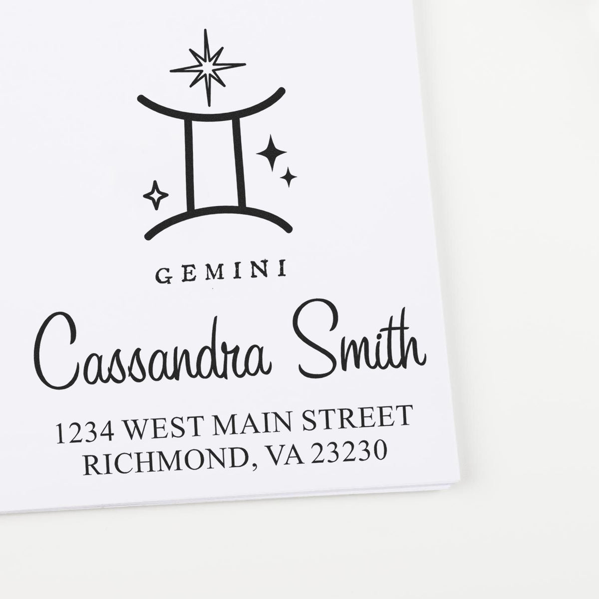 Black Gemini custom stamp and seal with stars, Cassandra Smith name, and Richmond, VA address on white paper.