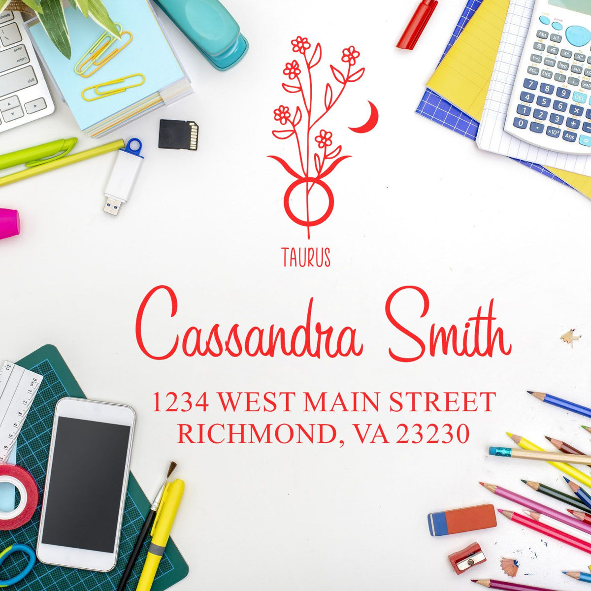 Red Taurus floral stamp seal with Cassandra Smith name and address on white, surrounded by colorful desk supplies.