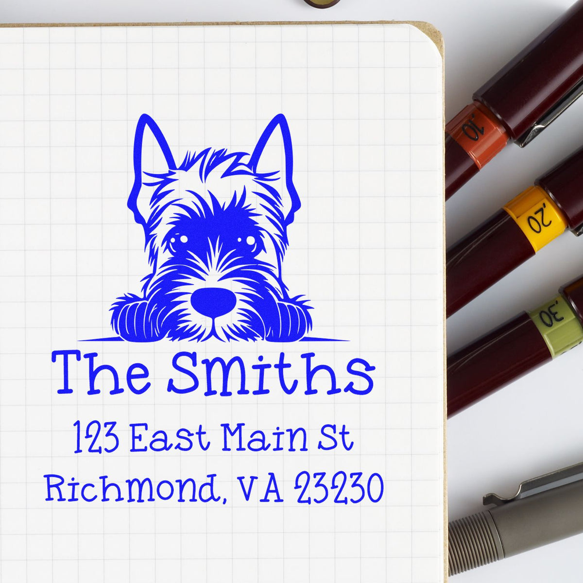 Blue custom address stamp with terrier logo and The Smiths, next to maroon seal pens with orange, yellow, and green bands.