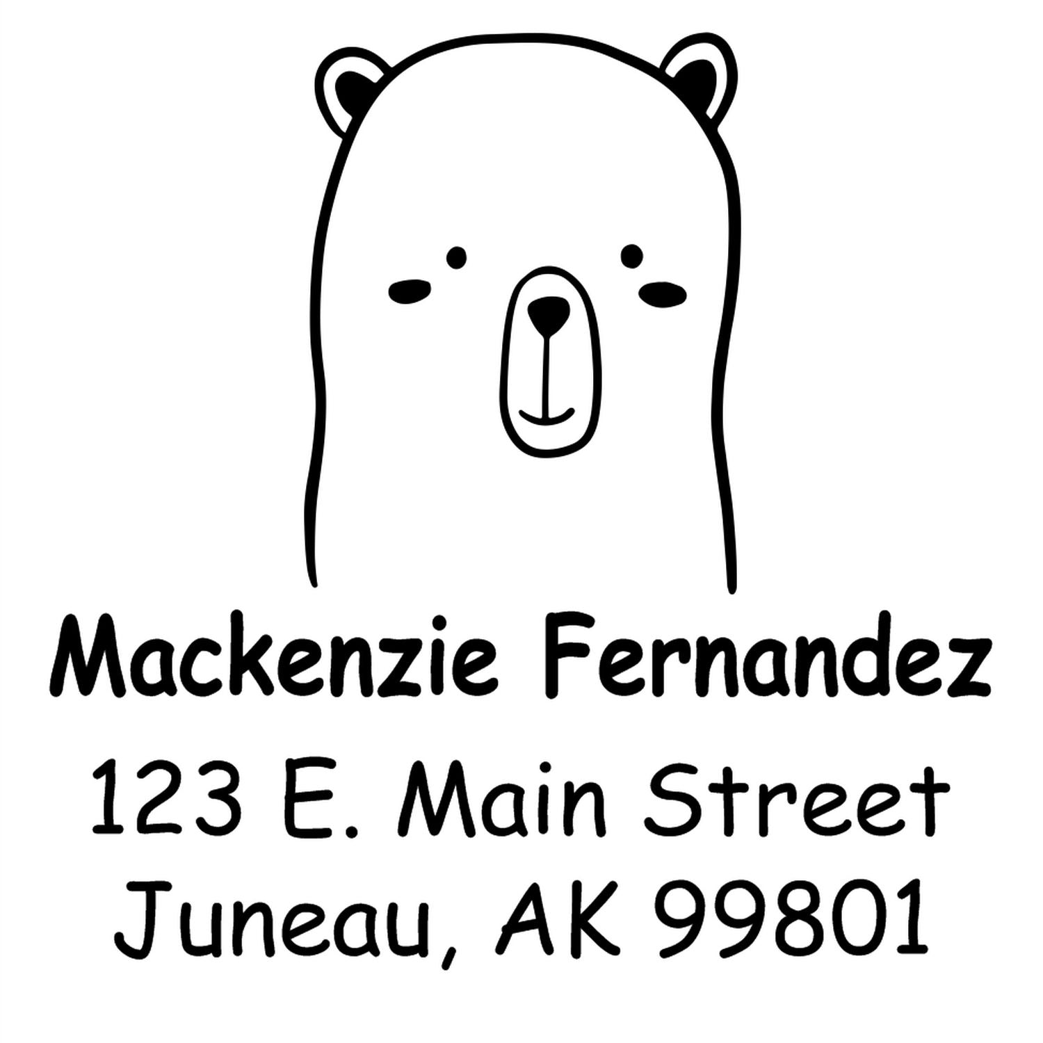 Adorable bear cartoon with a wood handle design on a personalized address stamper. The made-to-order mail stamp features the name "Mackenzie Fernandez" and address "123 E. Main Street, Juneau, AK 99801" in bold, playful font.