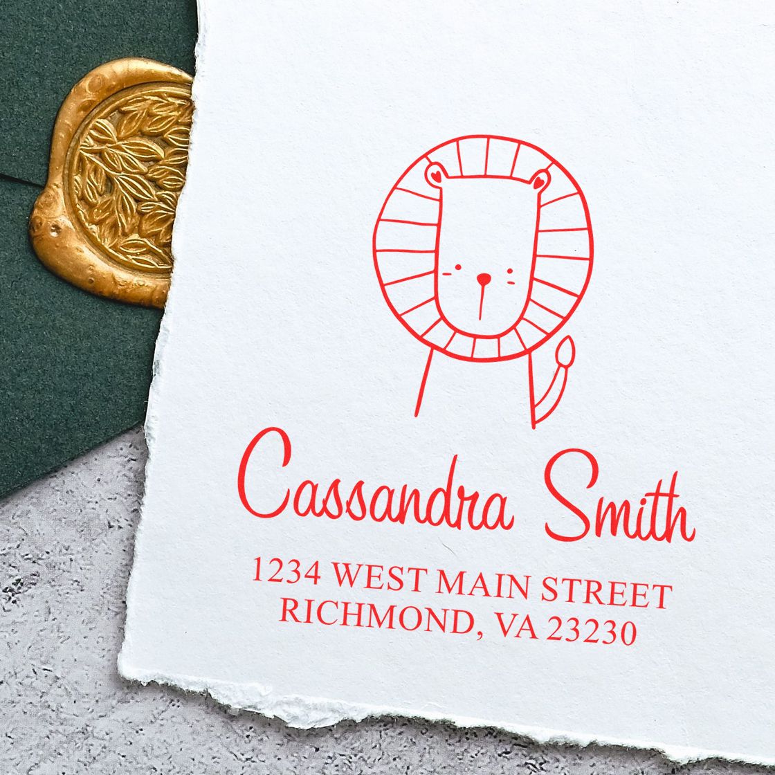 Wood handle stamper with a cartoon animal design, labeled "Little Roar," used for a personalized new address stamp. The image shows a return address stamper with a lion illustration and the name "Cassandra Smith" with an address in Richmond, VA.