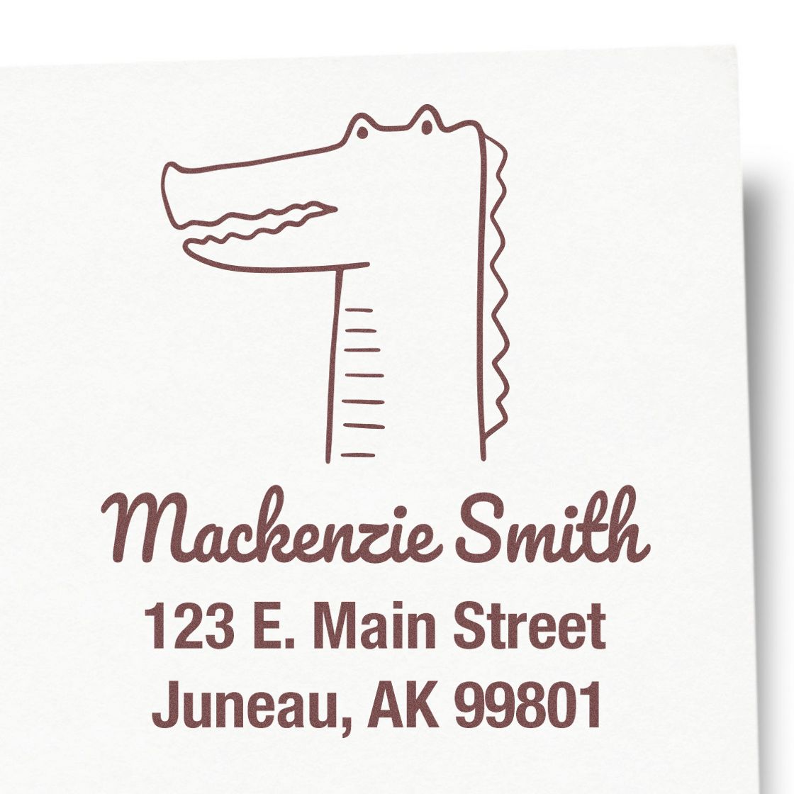 Wood handle bright-eyed crocodile cartoon animal made to order home address stamper. Customizable address stamp featuring a crocodile design above the name and address: Mackenzie Smith, 123 E. Main Street, Juneau, AK 99801.