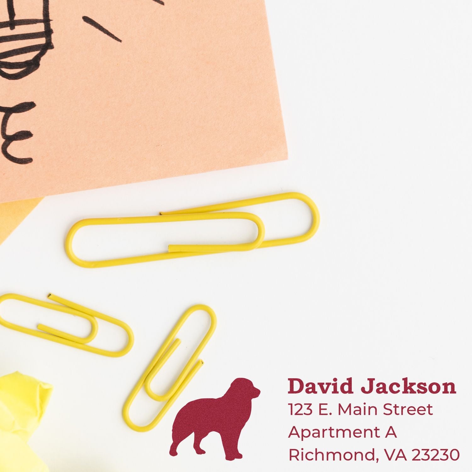 Australian Shepherd Silhouette Address Rubber Stamp on paper with yellow paperclips. Displays name and address in red text next to a dog silhouette.