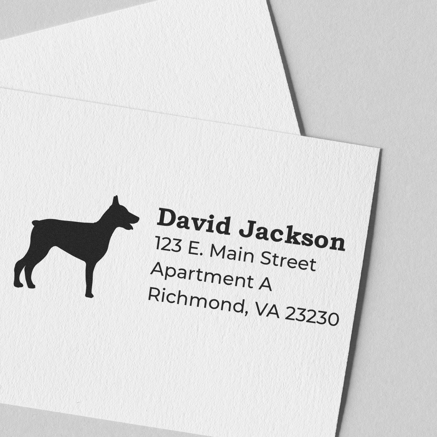 Self-Inking Doberman Dog Address Stamp on white paper, featuring a silhouette of a Doberman and sample address text in bold, clear font. Perfect for personalizing mail with style and ease.