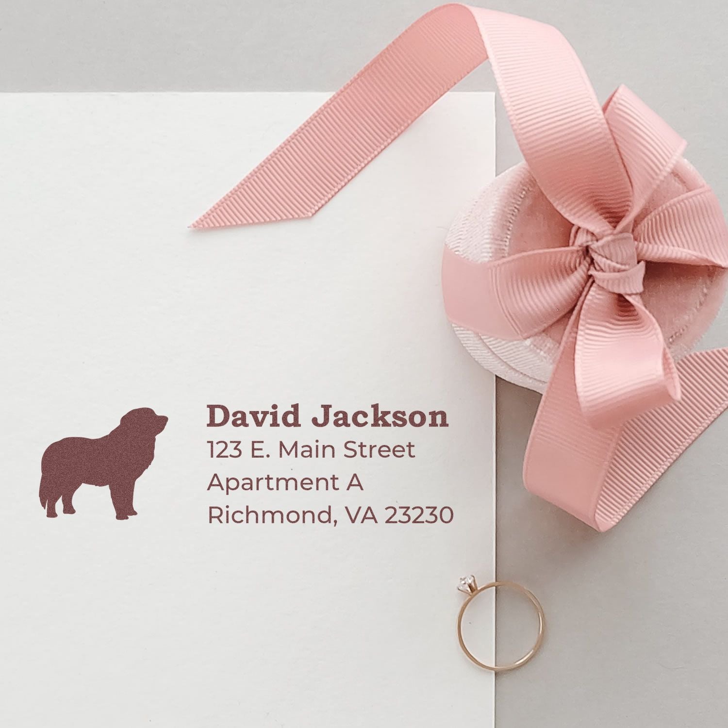 Slim Pre-Inked Pyrenees Address Stamp on white envelope with pink ribbon and ring. Features a dog silhouette and sample address in elegant font. Perfect for personalized stationery.