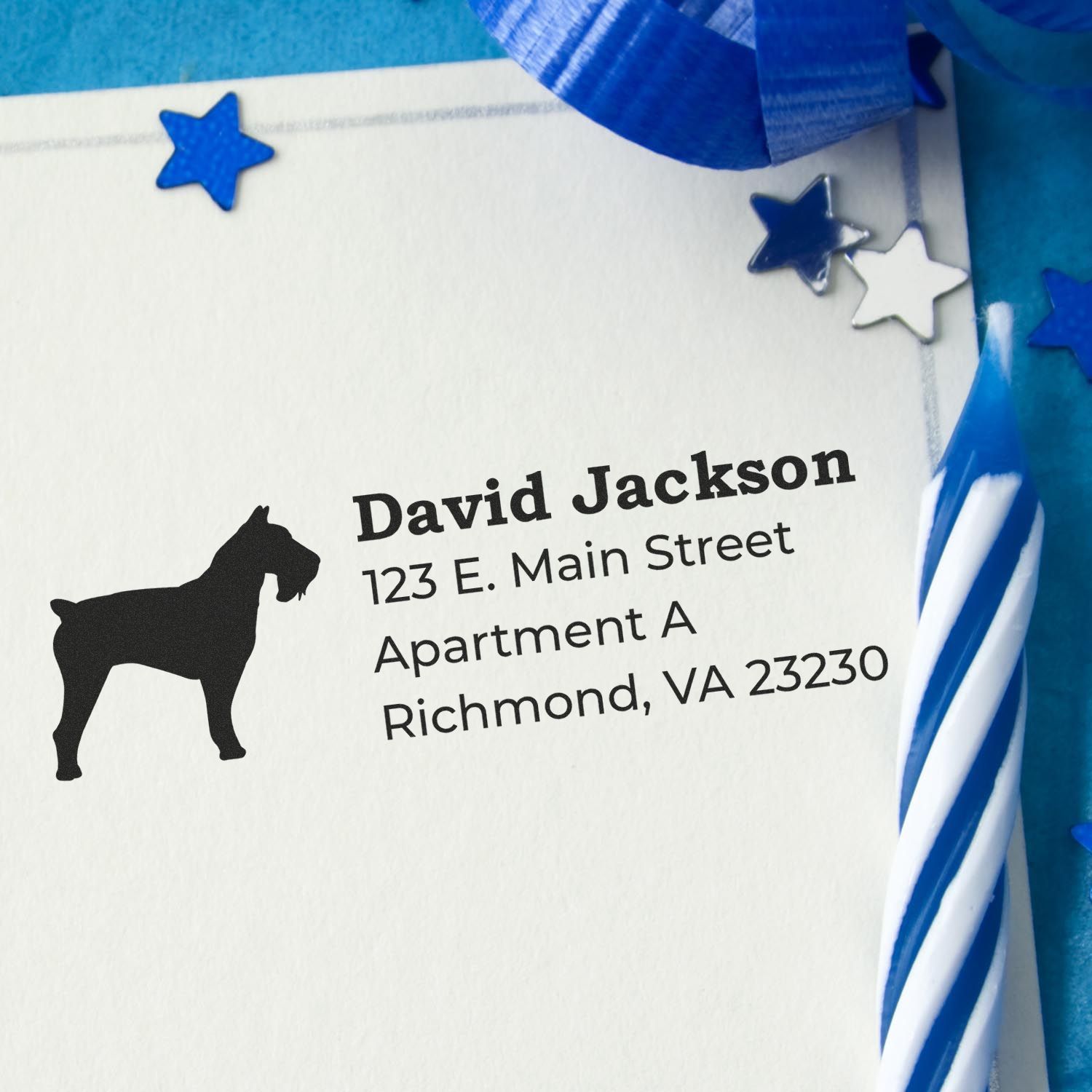 Self-Inking Schnauzer Dog Address Stamp on an envelope with blue decorations and a striped candle, showcasing a schnauzer silhouette and address details.