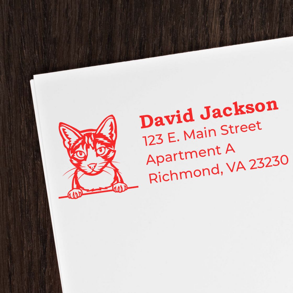 Wood Handle Aegean Cat Address Stamp in red ink on white paper, featuring a cute cat illustration next to a sample address. Perfect for personalizing mail with a touch of feline charm.