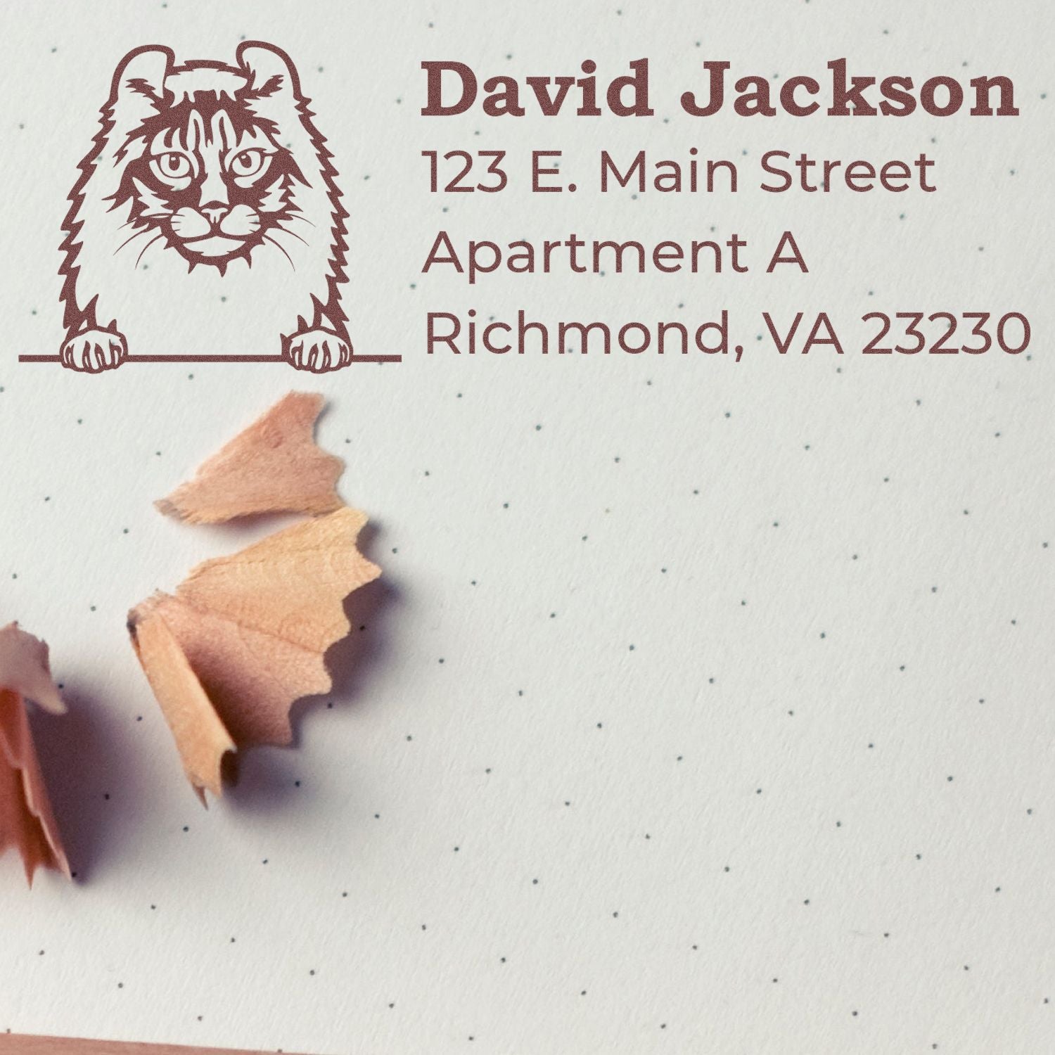 Wood Handle American Curl Cat Address Stamp on dotted paper, featuring a cat illustration and sample address. Pencil shavings add a creative touch. Ideal for personalized stationery.