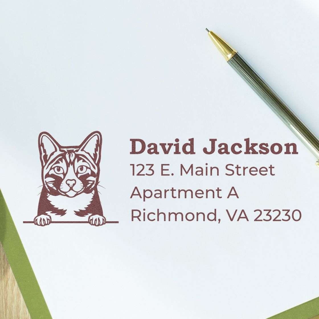 Wood Handle Arabian Mau Cat Address Stamp on white paper with a pen. Features a cat illustration above the address text, adding a personal touch to correspondence.