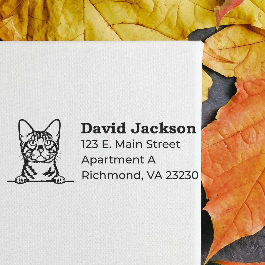 Wood Handle Bengal Cat Address Stamp on white paper with a Bengal cat illustration, surrounded by autumn leaves. Text includes a sample address in bold, black font.