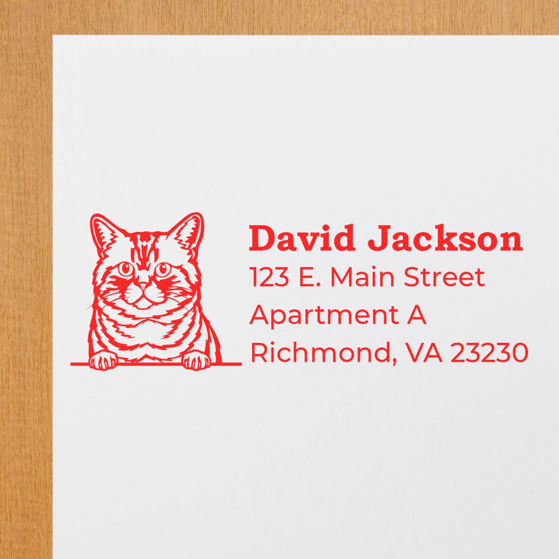 Self-Inking Brazilian Shorthair Custom Address Stamp featuring a red cat design and personalized address details on white paper, placed on a wooden surface.