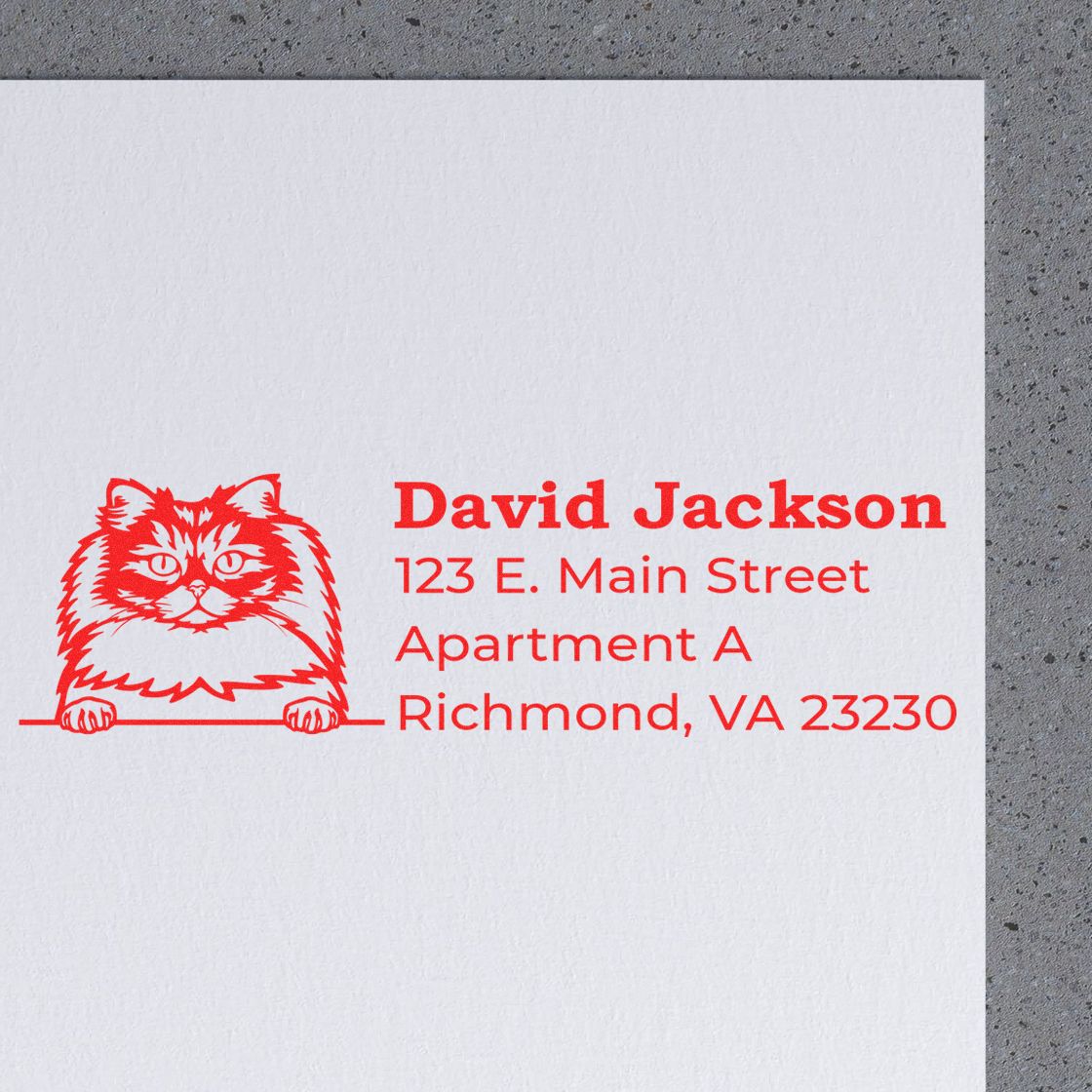 Self-Inking British Longhair Custom Address Stamp featuring a red cat design and sample address on white paper, placed on a gray surface.