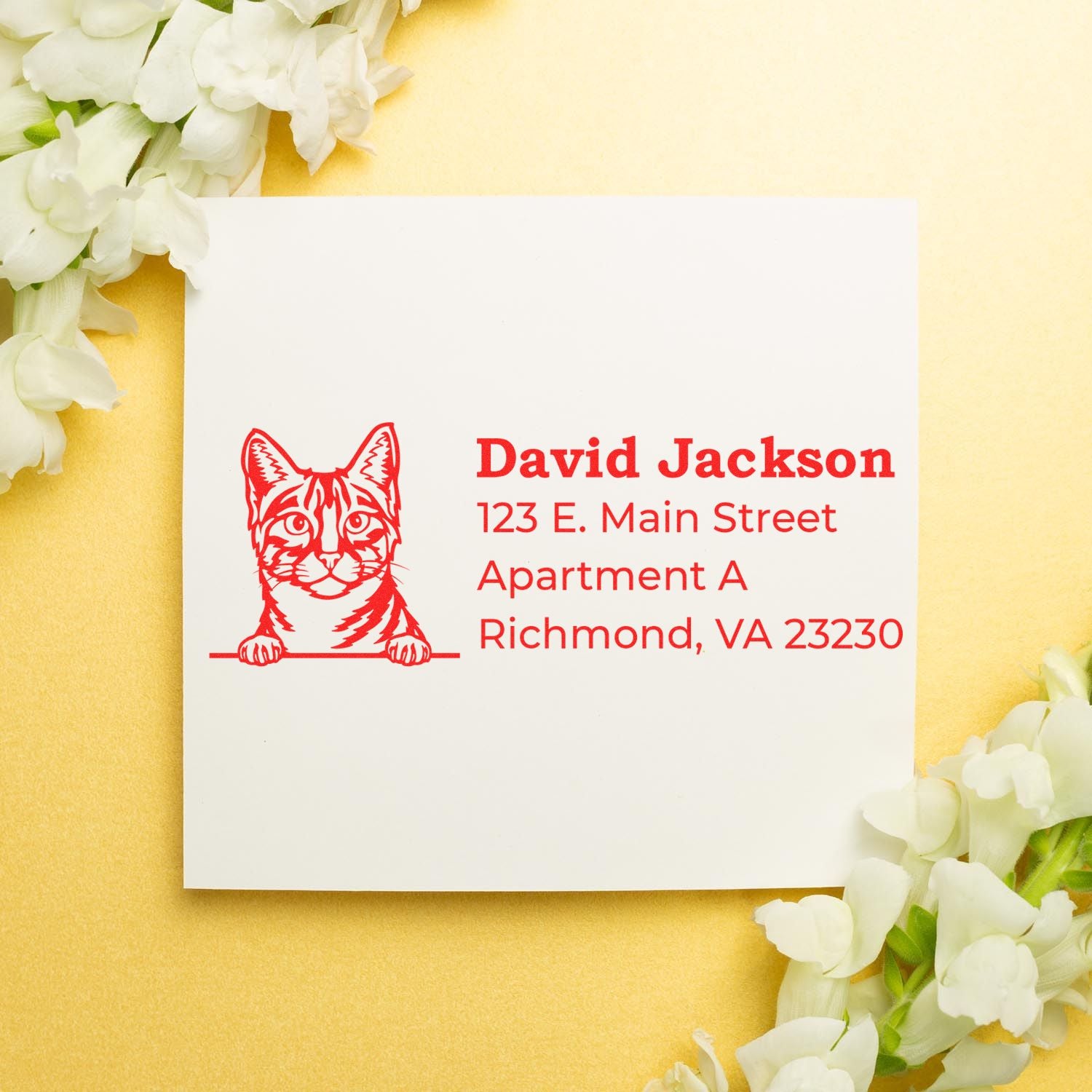 PSI Pre-Inked Peeking Egyptian Mau Cat Personalized Address Stamp on white card with red text, featuring a cat illustration. Card is surrounded by white flowers on a gold background.