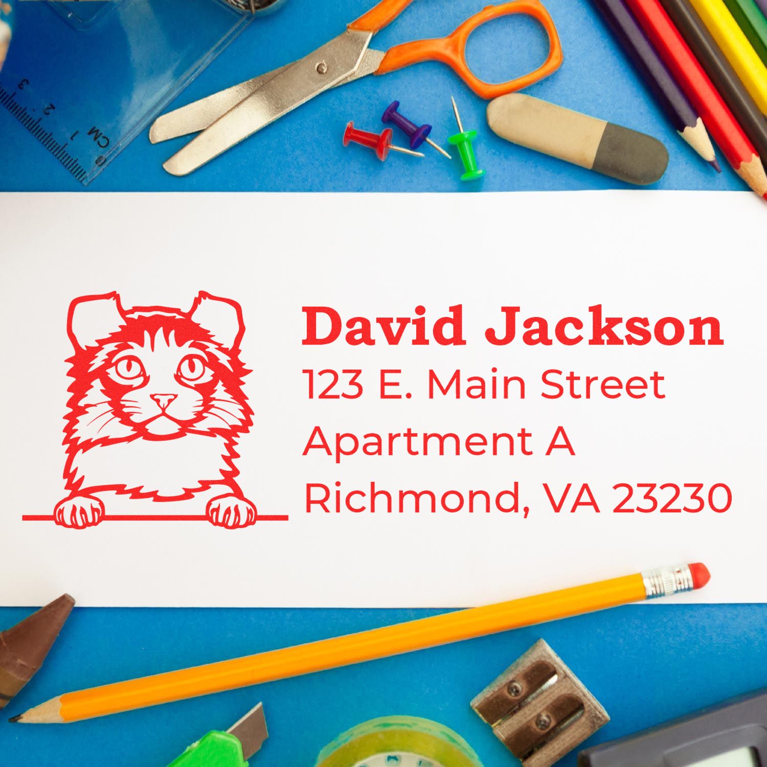 Wood Handle Kinkalow Cat Address Stamp on a white envelope surrounded by colorful office supplies, featuring a red cat design and sample address in bold red text.