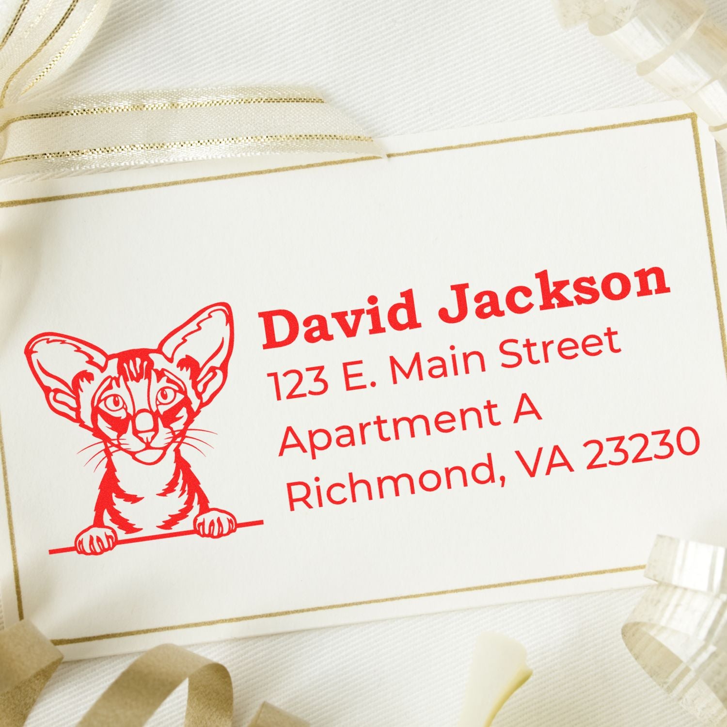 Self-Inking Oriental Shorthair Custom Address Stamp on a card with a red cat illustration and sample address, surrounded by decorative ribbons.