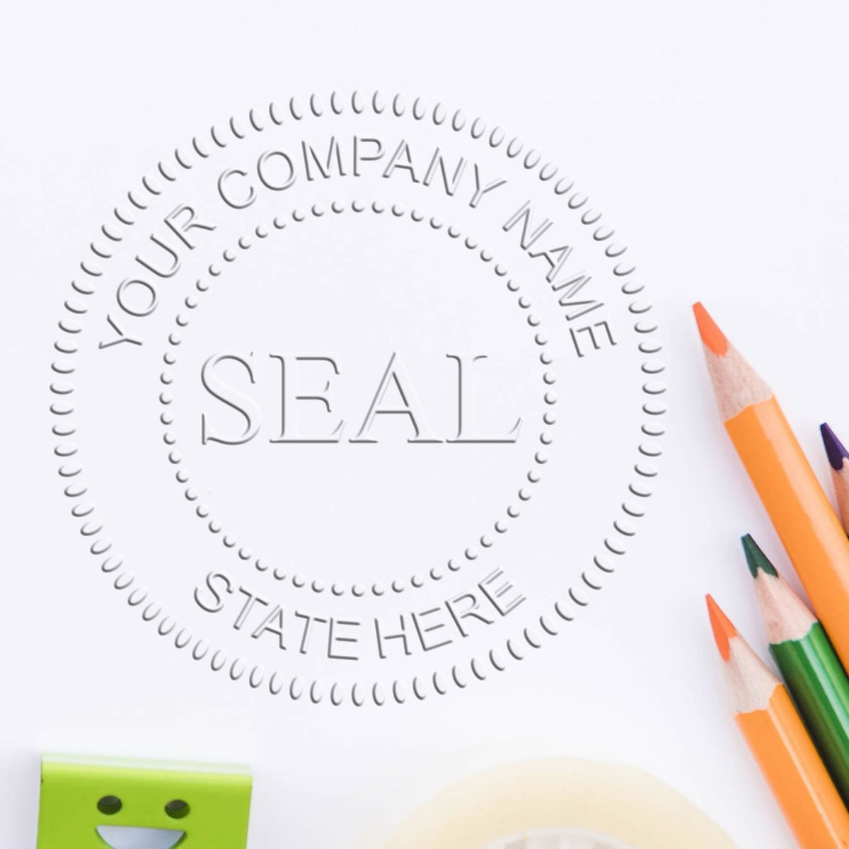 Custom gray company seal stamp with dotted border and colored pencils on a white background