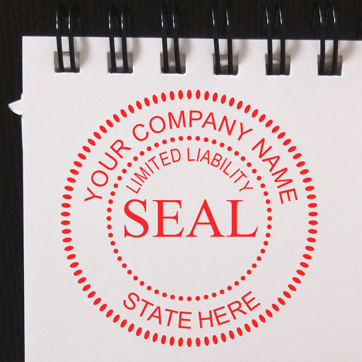 Red custom company seal stamp with dotted circular border, Your Company Name, Limited Liability, and State Here on white pad.