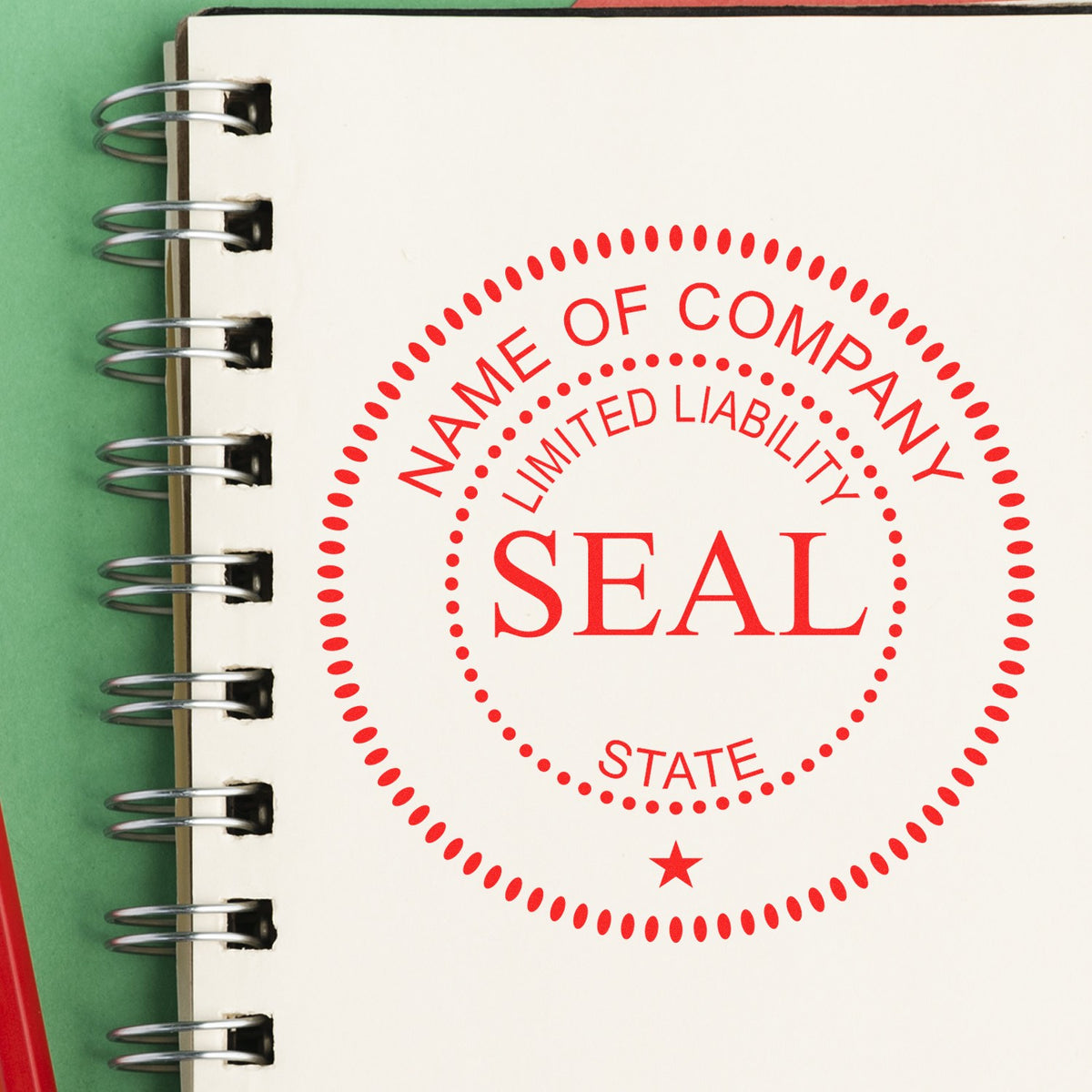 Red company seal stamp imprint on a white spiral notebook page with green background