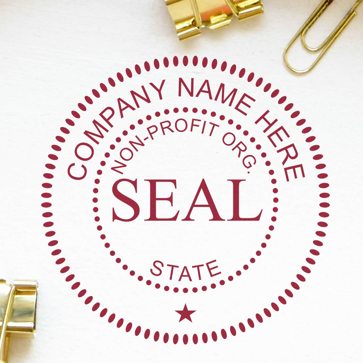 Maroon custom nonprofit state seal stamp with dotted circular border and star on white paper, framed by gold paper clips.