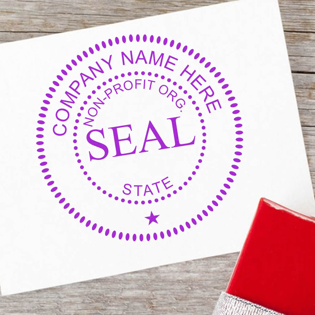 Purple custom non-profit company name seal stamp in violet on white paper, with a red rubber stamp handle