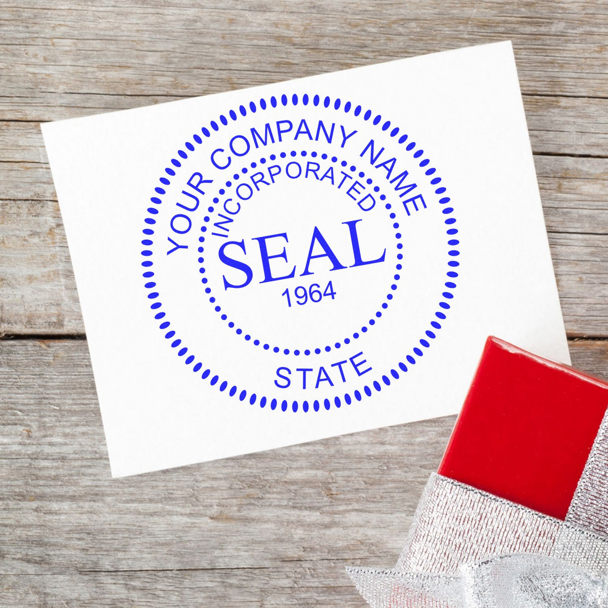 Blue custom corporate seal stamp on white card with dotted circle, Your Company Name, Incorporated, and State, beside a red ink pad.