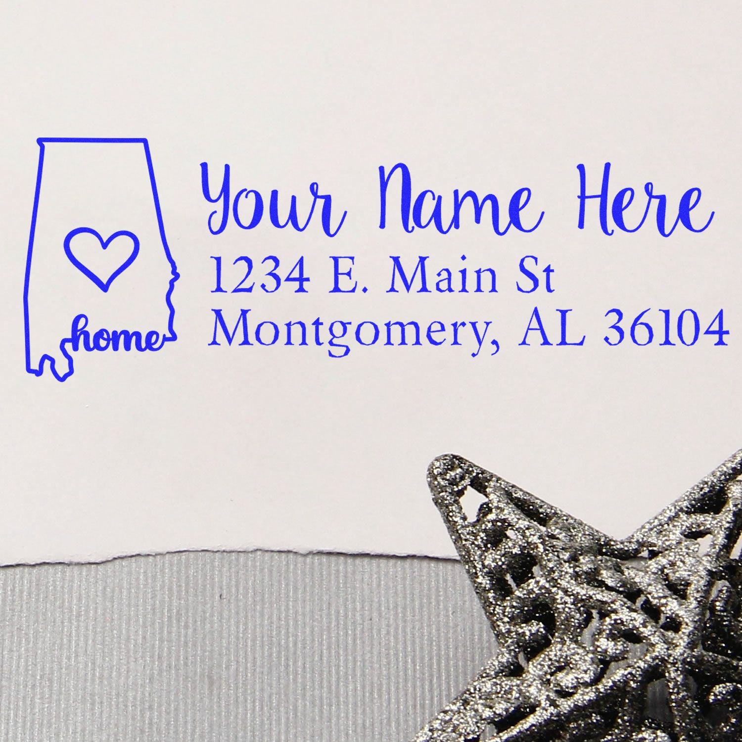 Wood Handle Alabama Custom Address Rubber Stamp on white paper, featuring a blue design with a heart inside the Alabama state outline, personalized address, and decorative silver star accent.