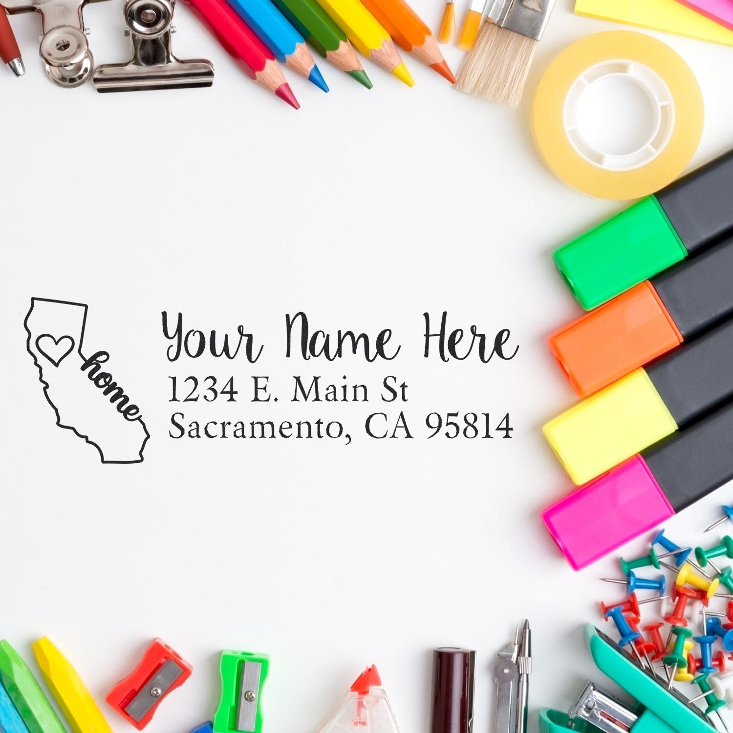 PSI Pre-Inked Personalized California State Love Address Stamp on white paper surrounded by colorful office supplies, including markers, pencils, and clips.