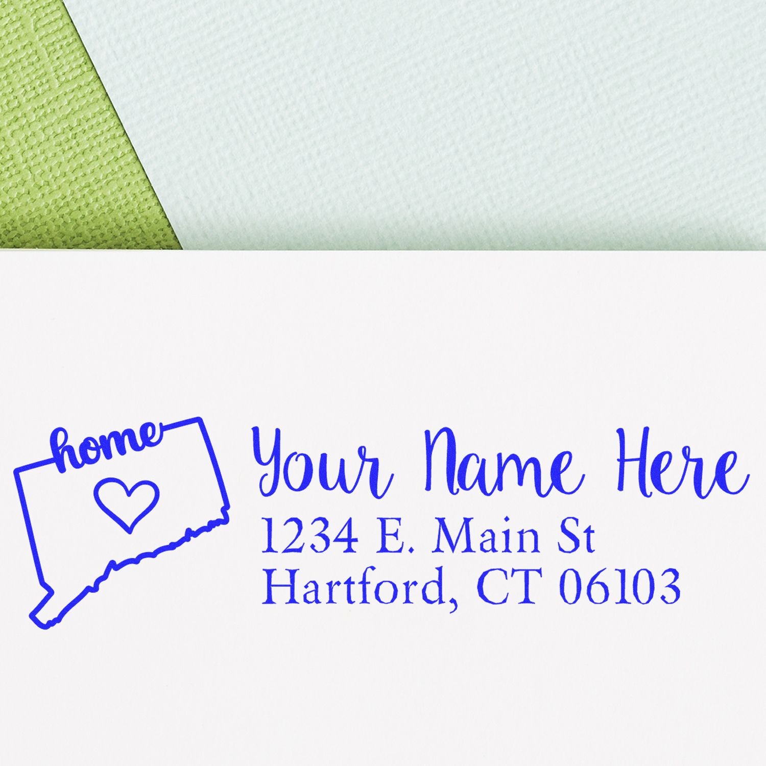 Image of an envelope stamped with the Connecticut Self-Inking State Love Address Stamp, featuring a blue outline of Connecticut with a heart and the word home, alongside a sample address.