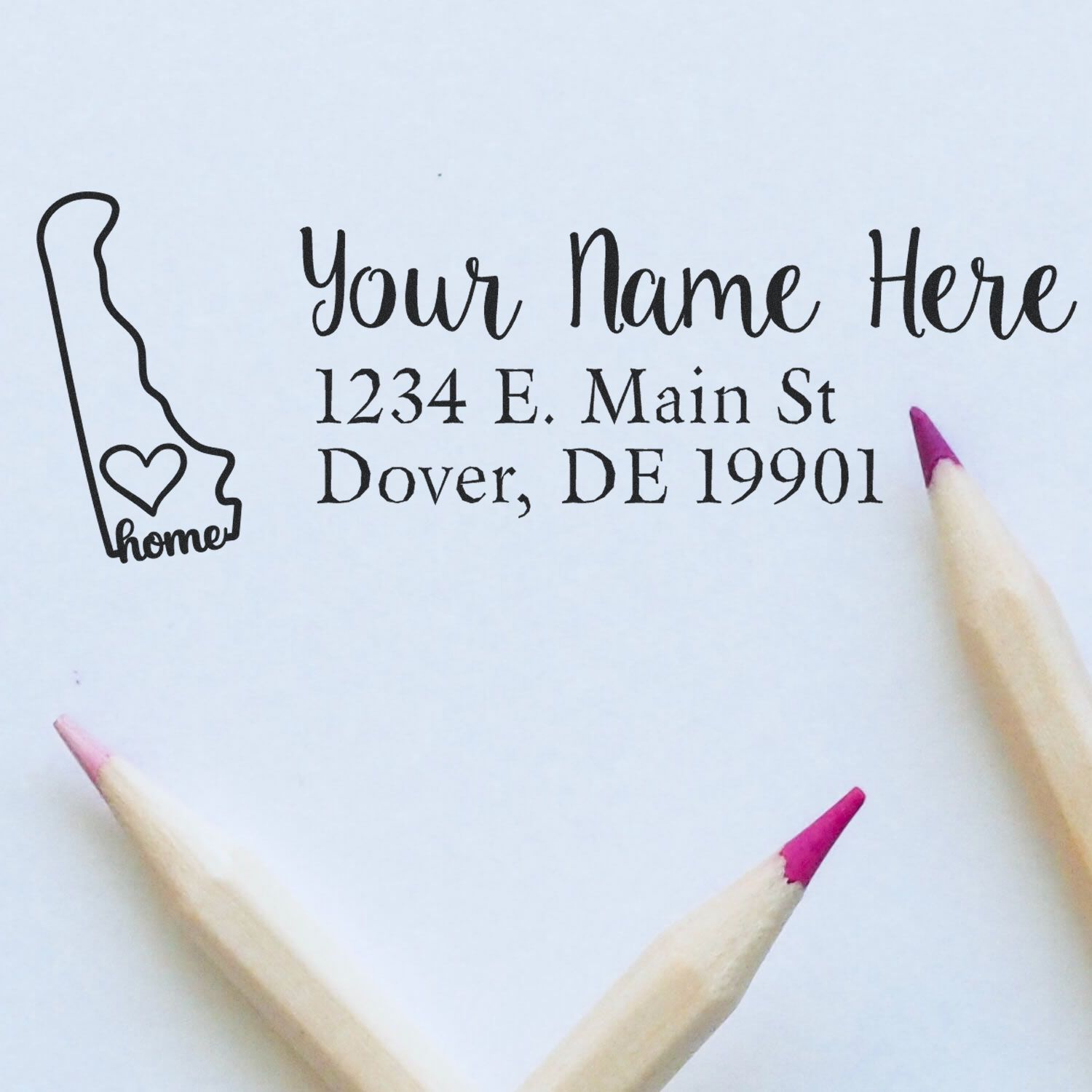 PSI Pre-Inked Personalized Delaware State Love Address Stamp on paper with a Delaware outline and heart, next to two pink-tipped pencils.