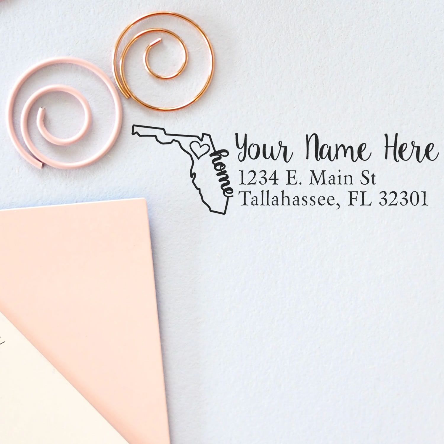 PSI Pre-Inked Personalized Florida State Love Address Stamp on paper, featuring a Florida outline with home text, next to pink and gold paper clips.