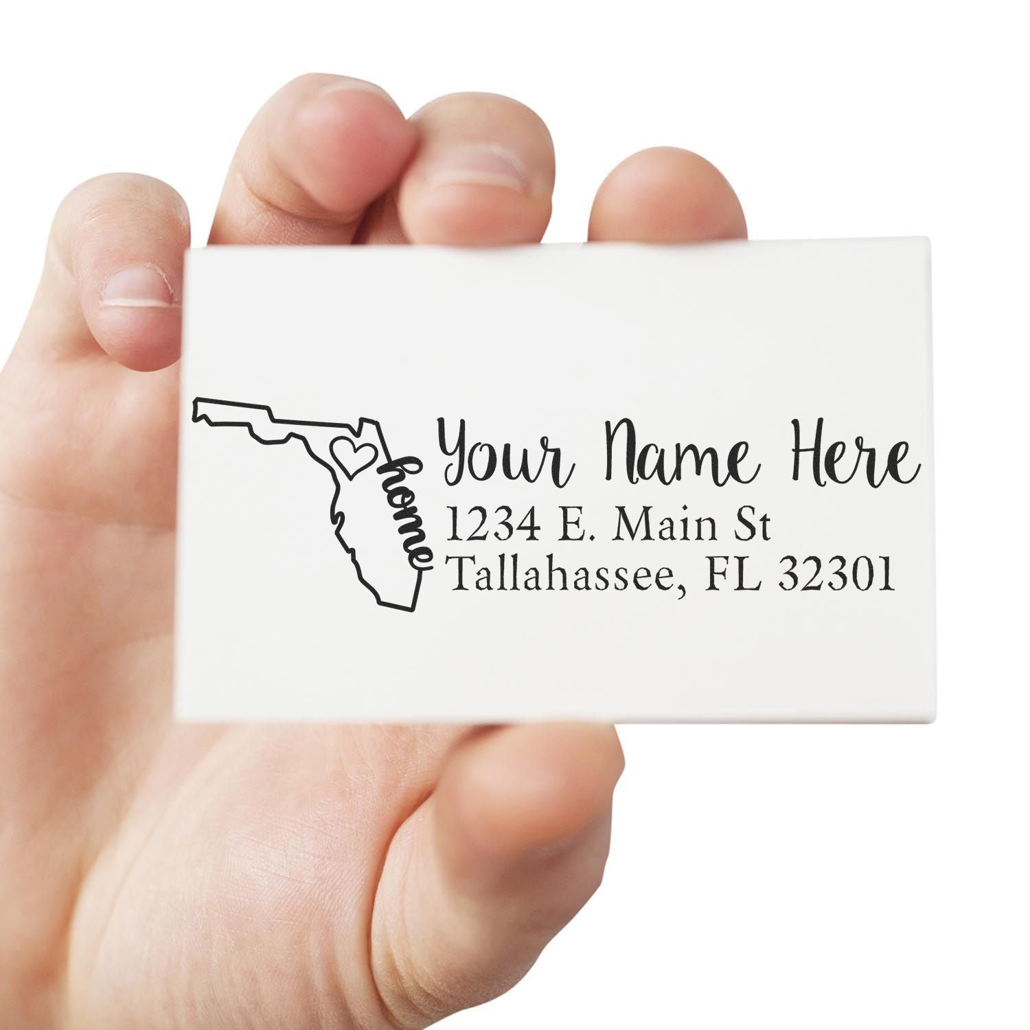 Hand holding a Slim Pre-Inked Florida State Love Custom Address Stamp featuring a Florida outline with a heart, personalized with Your Name Here and an address in Tallahassee, FL.