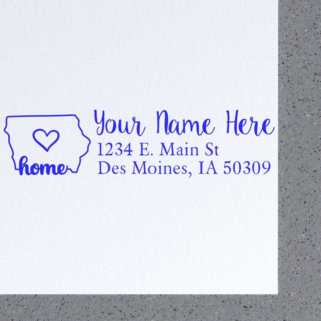 Slim Pre-Inked Iowa State Love Custom Address Stamp on white paper, featuring a heart inside the state outline with home text, personalized address, and elegant blue script.