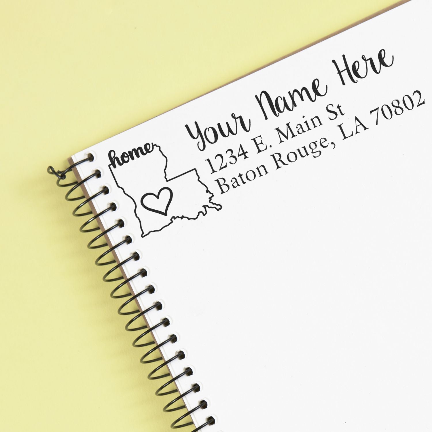 PSI Pre-Inked Personalized Louisiana State Love Address Stamp on a notebook page, featuring a heart inside the state outline with customizable address and name in elegant script.