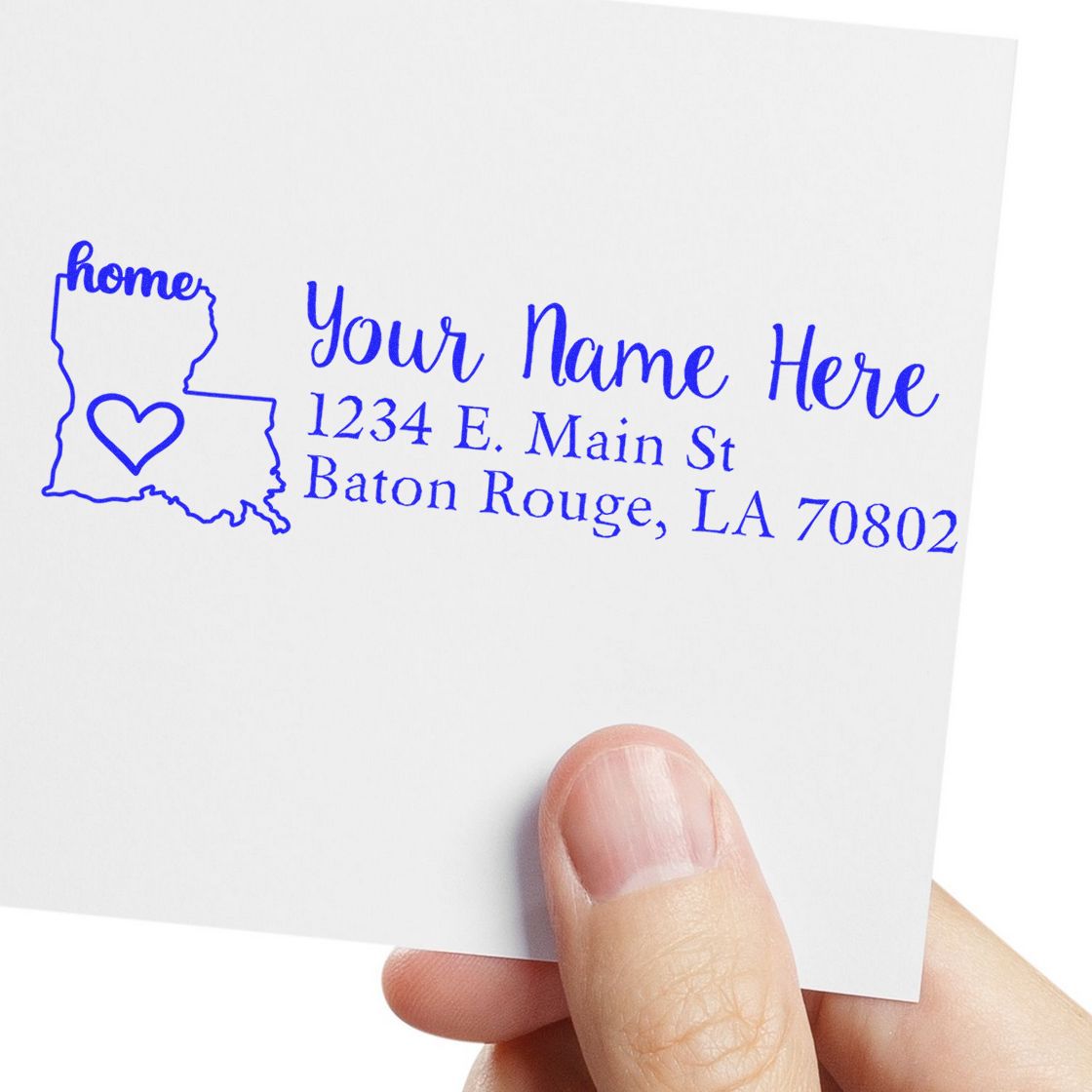 A hand holds a card stamped with the PSI Pre-Inked Personalized Louisiana State Love Address Stamp, featuring a heart inside the state outline and customizable address text in blue.