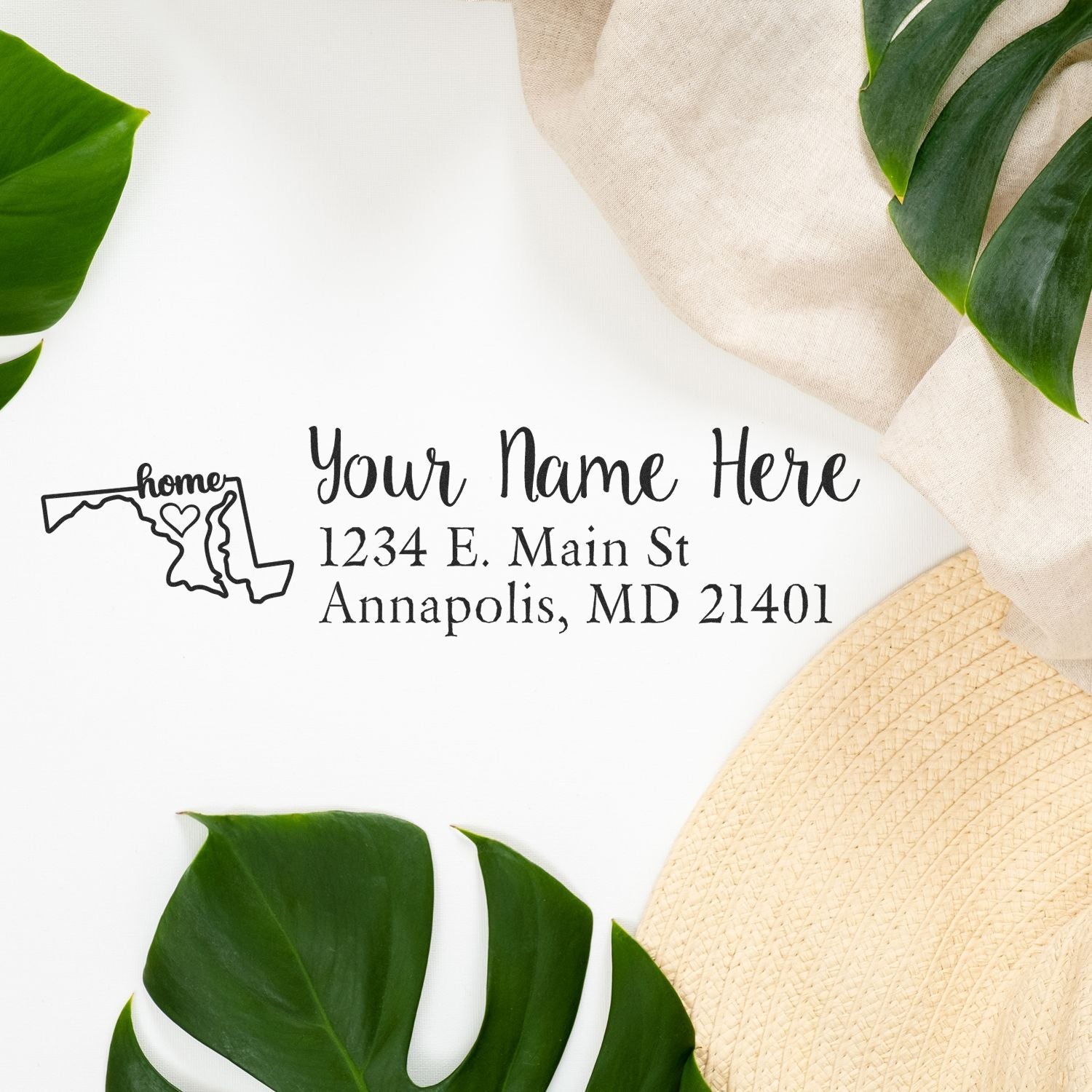 Wood Handle Maryland Custom Address Rubber Stamp on a white surface with green leaves and a beige hat. The stamp design includes a Maryland map outline and customizable address text.