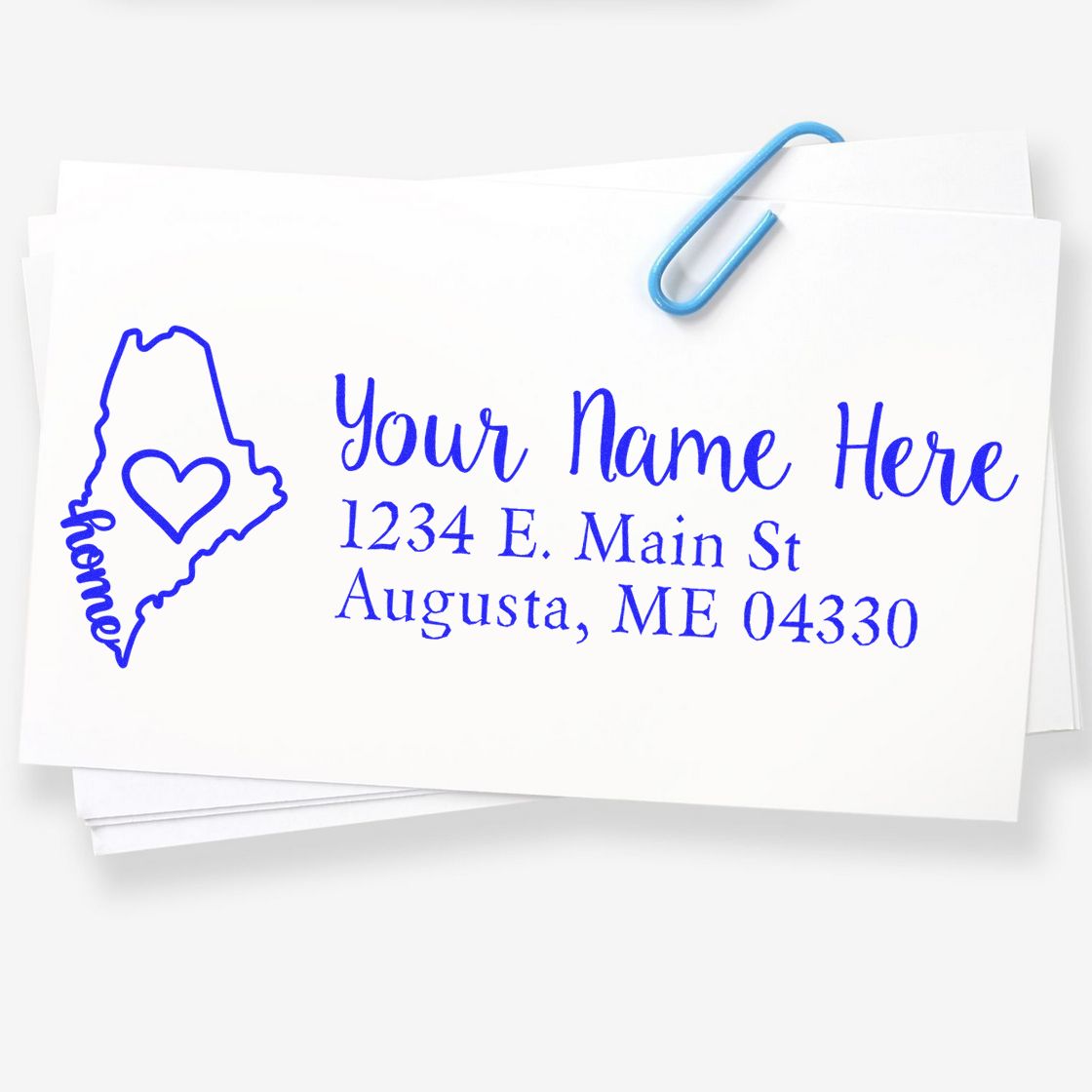 Maine Self-Inking State Love Address Stamp on white paper, featuring a blue outline of Maine with a heart and the word home, alongside customizable address text.