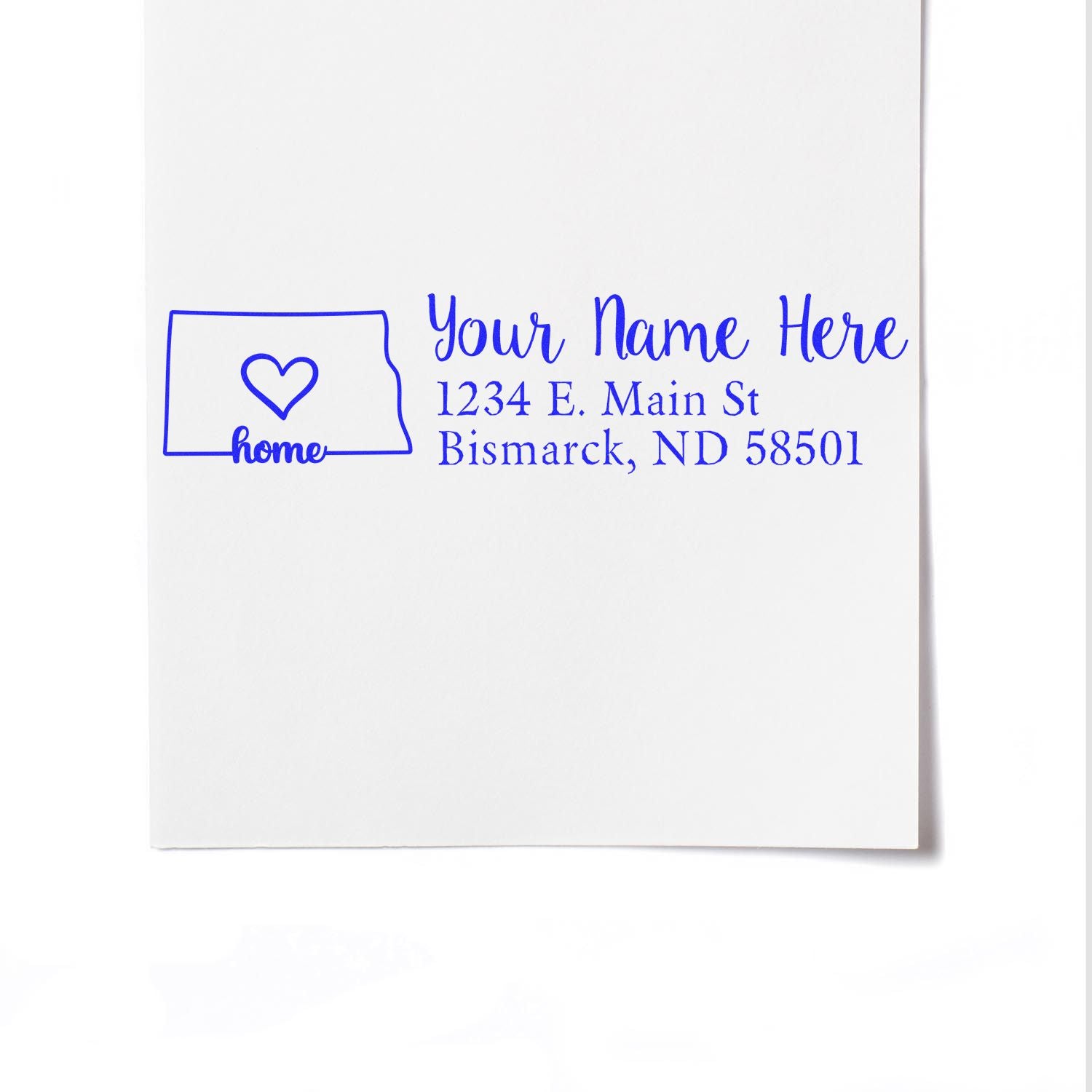 North Dakota Self-Inking State Love Address Stamp on white paper, featuring a heart inside the state outline and customizable address text in blue.