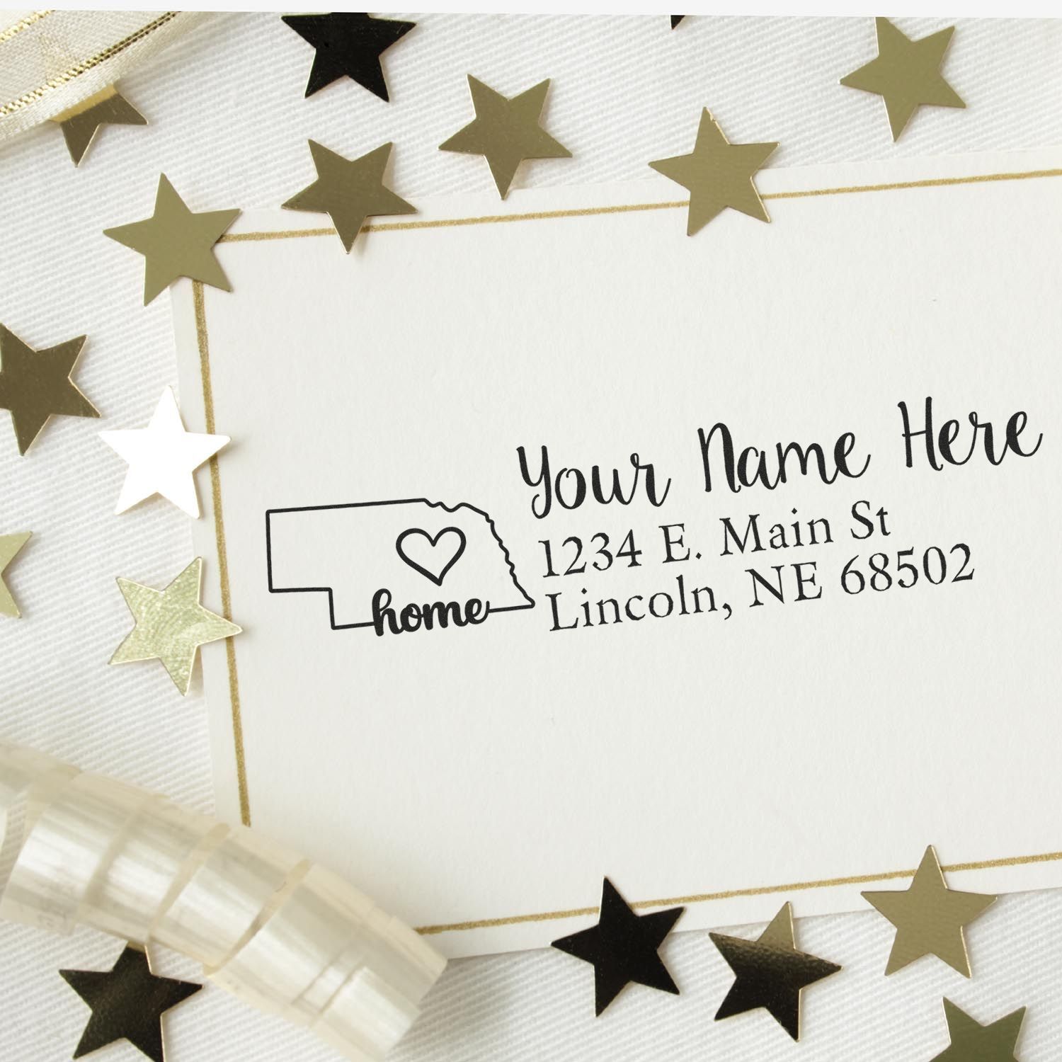 Wood Handle Nebraska Custom Address Rubber Stamp on a card with gold stars. The stamp features a heart and the word home inside the Nebraska state outline, with customizable address text.