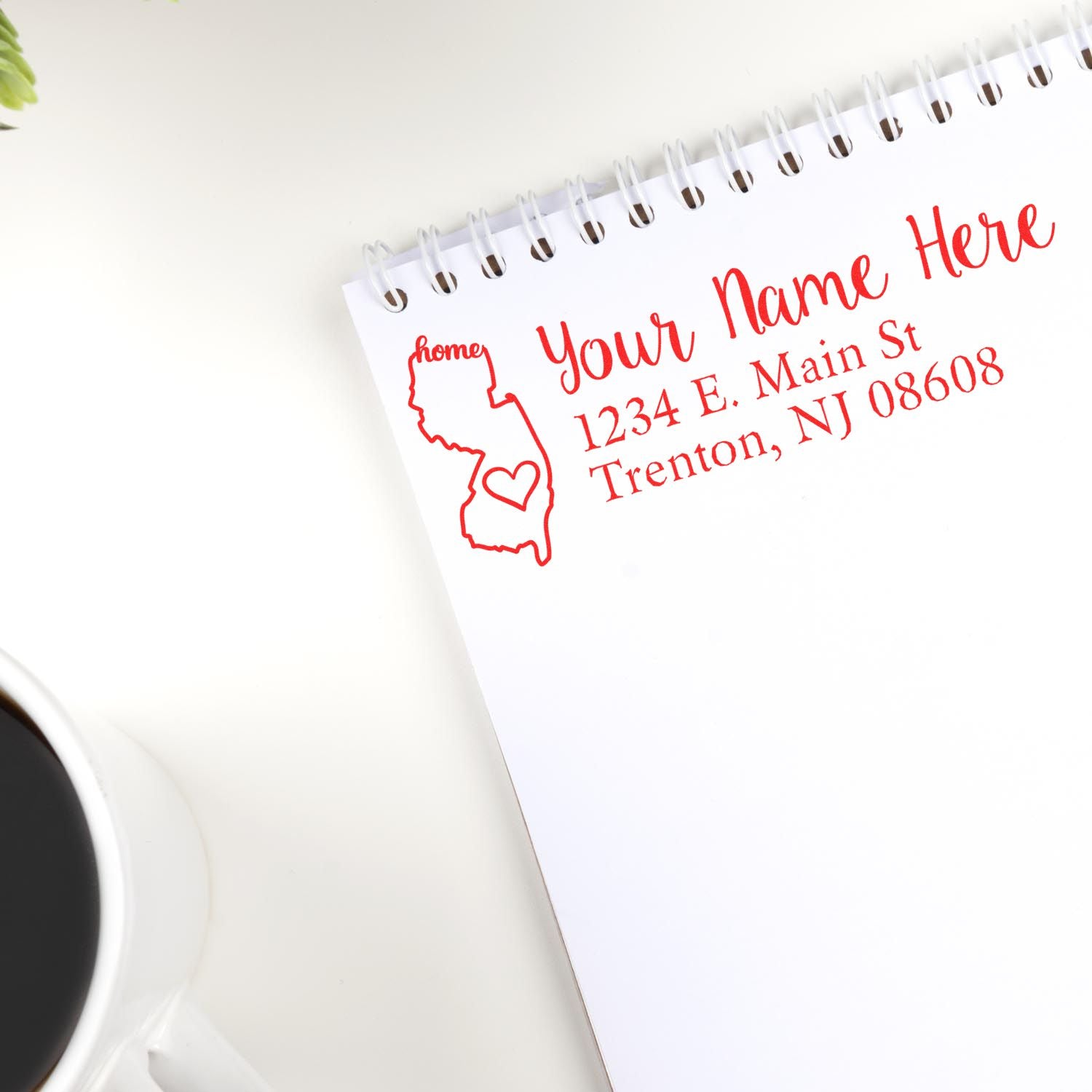 PSI Pre-Inked Personalized New Jersey State Love Address Stamp on notepad, featuring a red outline of New Jersey with a heart, next to a cup of coffee.