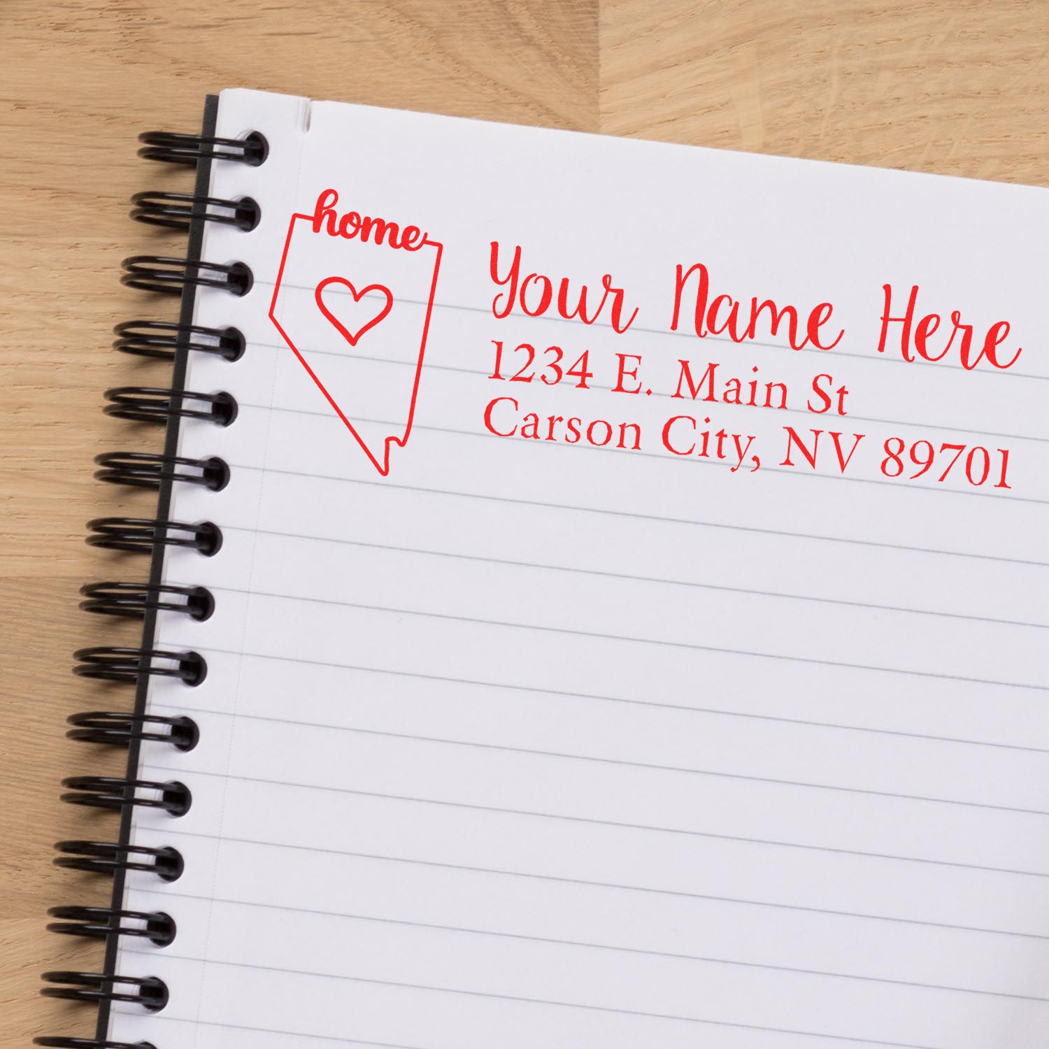 Wood Handle Nevada Custom Address Rubber Stamp in use on a notebook, displaying a red address with a heart and home text inside a Nevada outline.