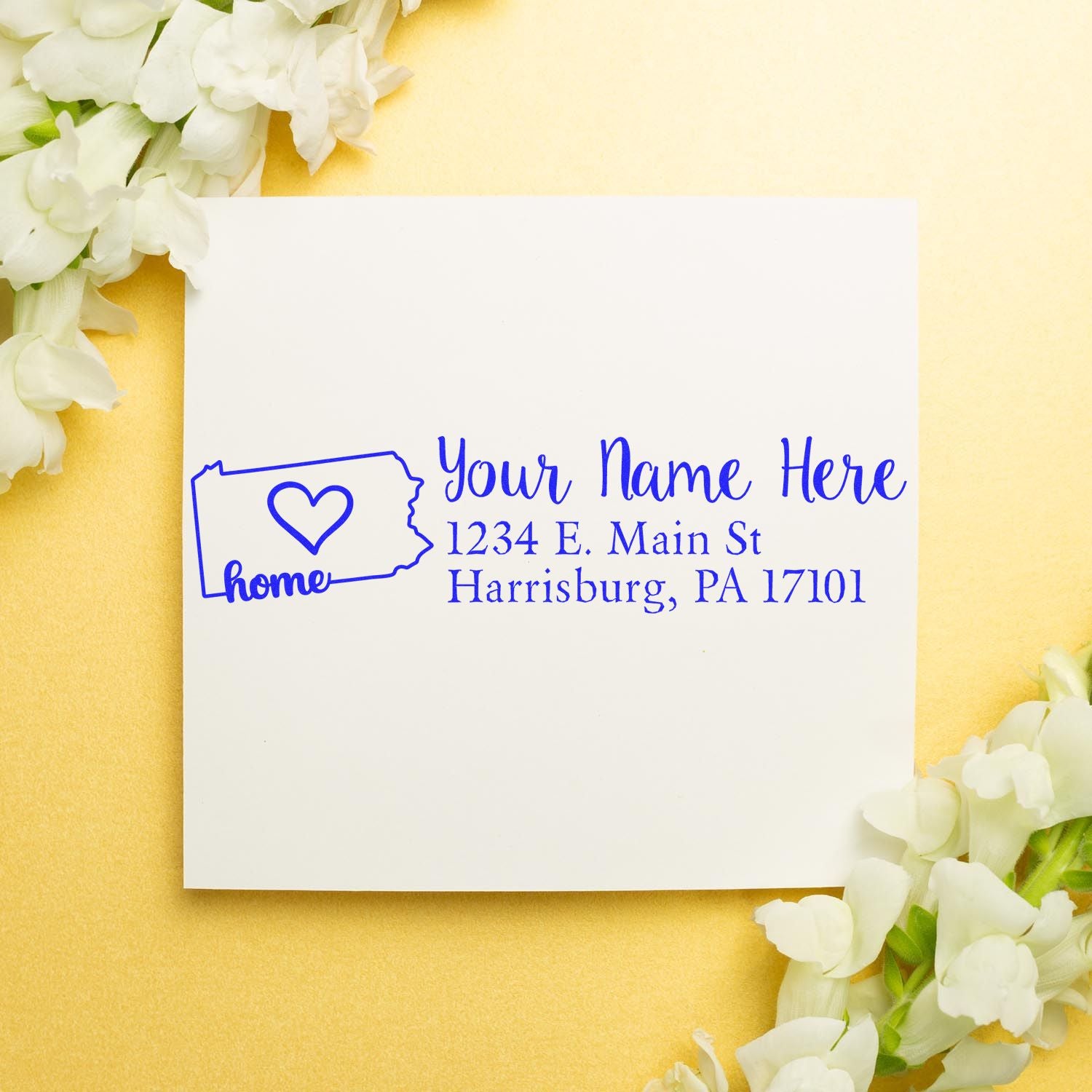 Wood Handle Pennsylvania Custom Address Rubber Stamp on white paper with blue ink, featuring a heart and state outline. Surrounded by white flowers on a gold background.