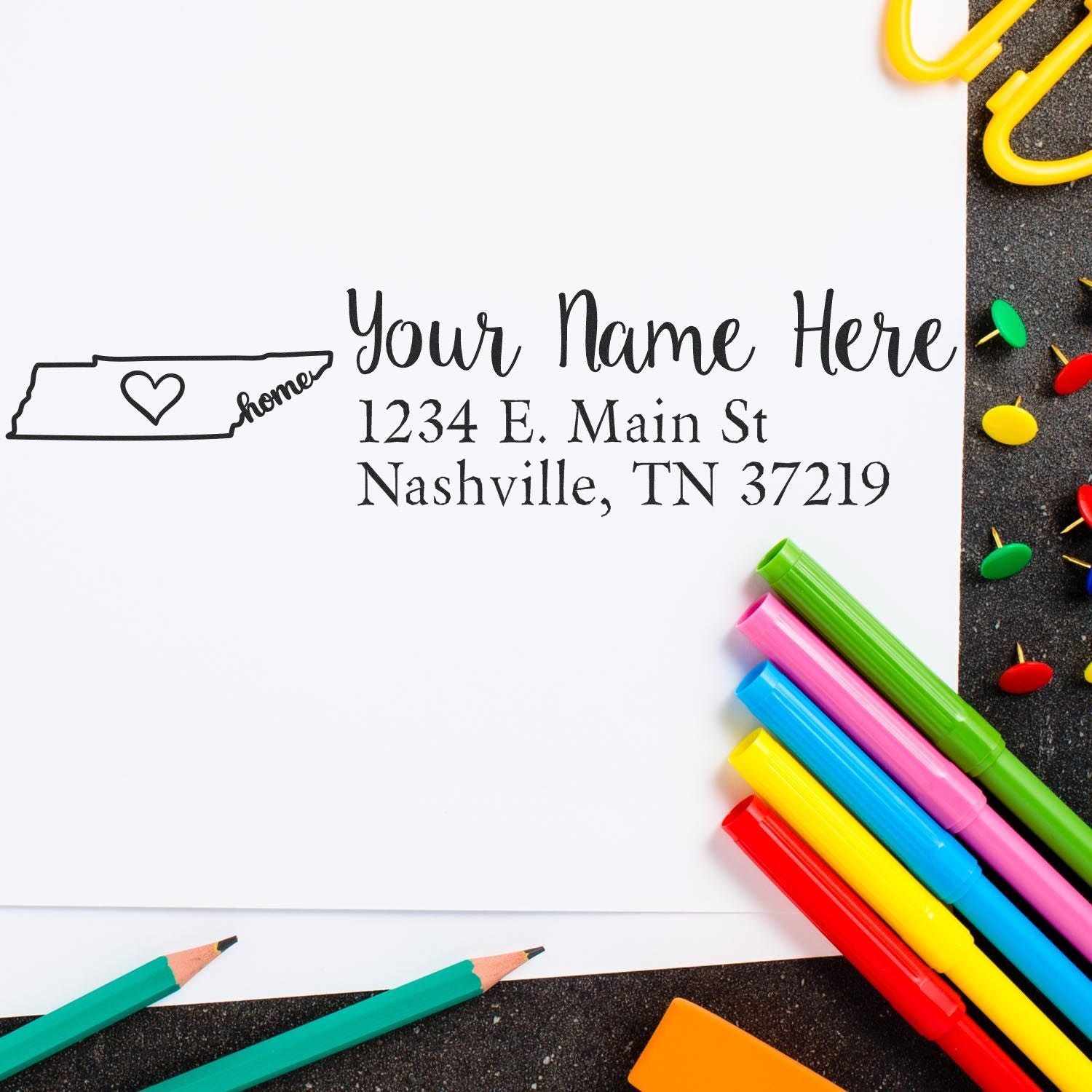 PSI Pre-Inked Personalized Tennessee State Love Address Stamp on paper with colorful pens and push pins. Features a Tennessee outline with a heart and customizable address text.