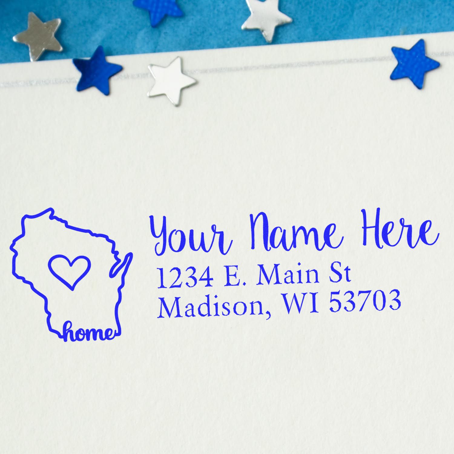 Wood Handle Wisconsin Custom Address Rubber Stamp on an envelope, featuring a blue outline of Wisconsin with a heart and the word home, surrounded by blue and silver star decorations.