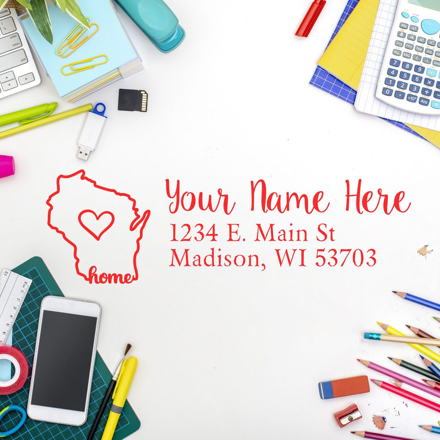 Desk with stationery and a Wisconsin Self-Inking State Love Address Stamp imprint showing a heart in Wisconsin, personalized with Your Name Here and an address in red ink.