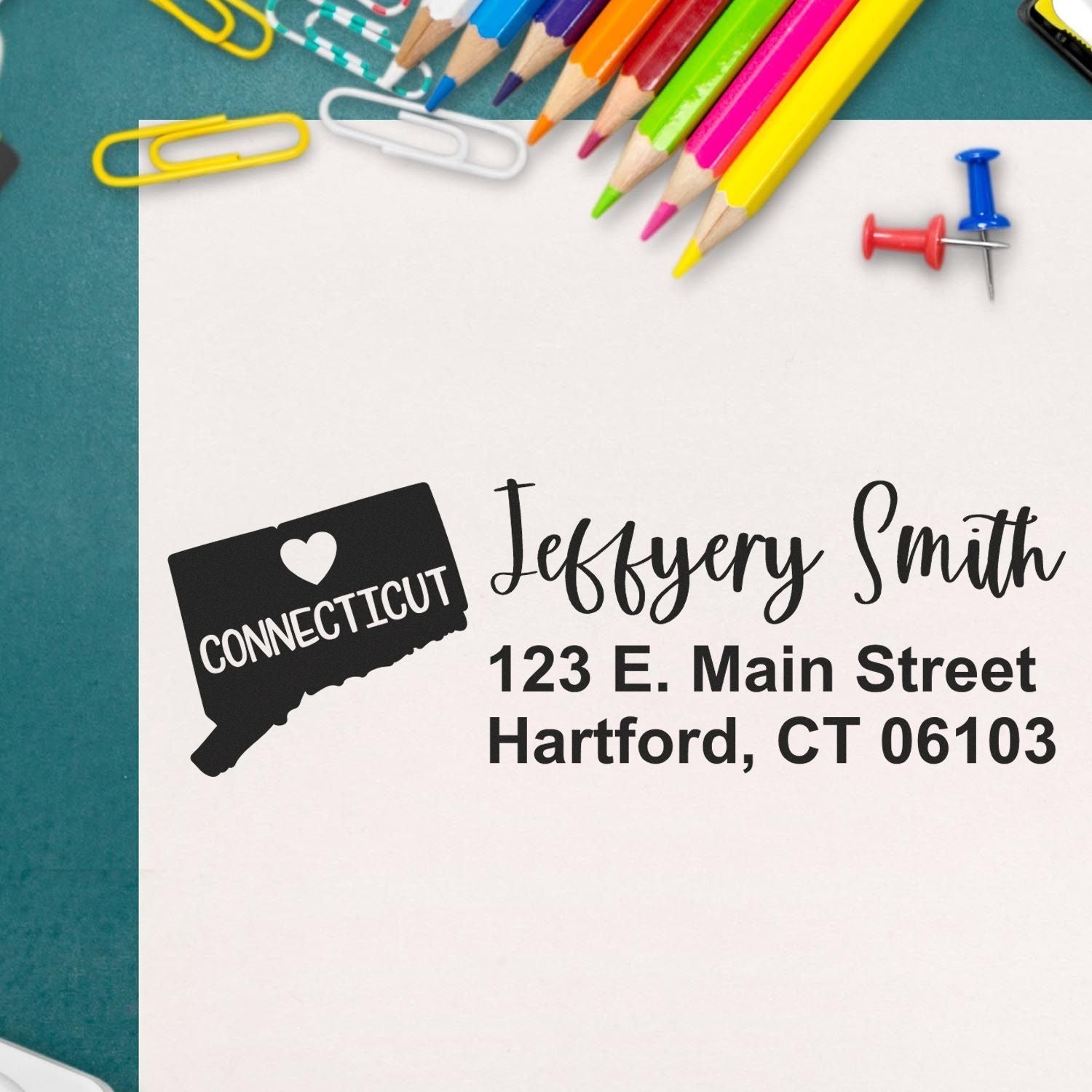 Connecticut State Love Personalized Address Stamp on paper with colorful pencils, paperclips, and push pins. Features a heart design and sample address: Jeffery Smith, 123 E. Main Street, Hartford, CT 06103.